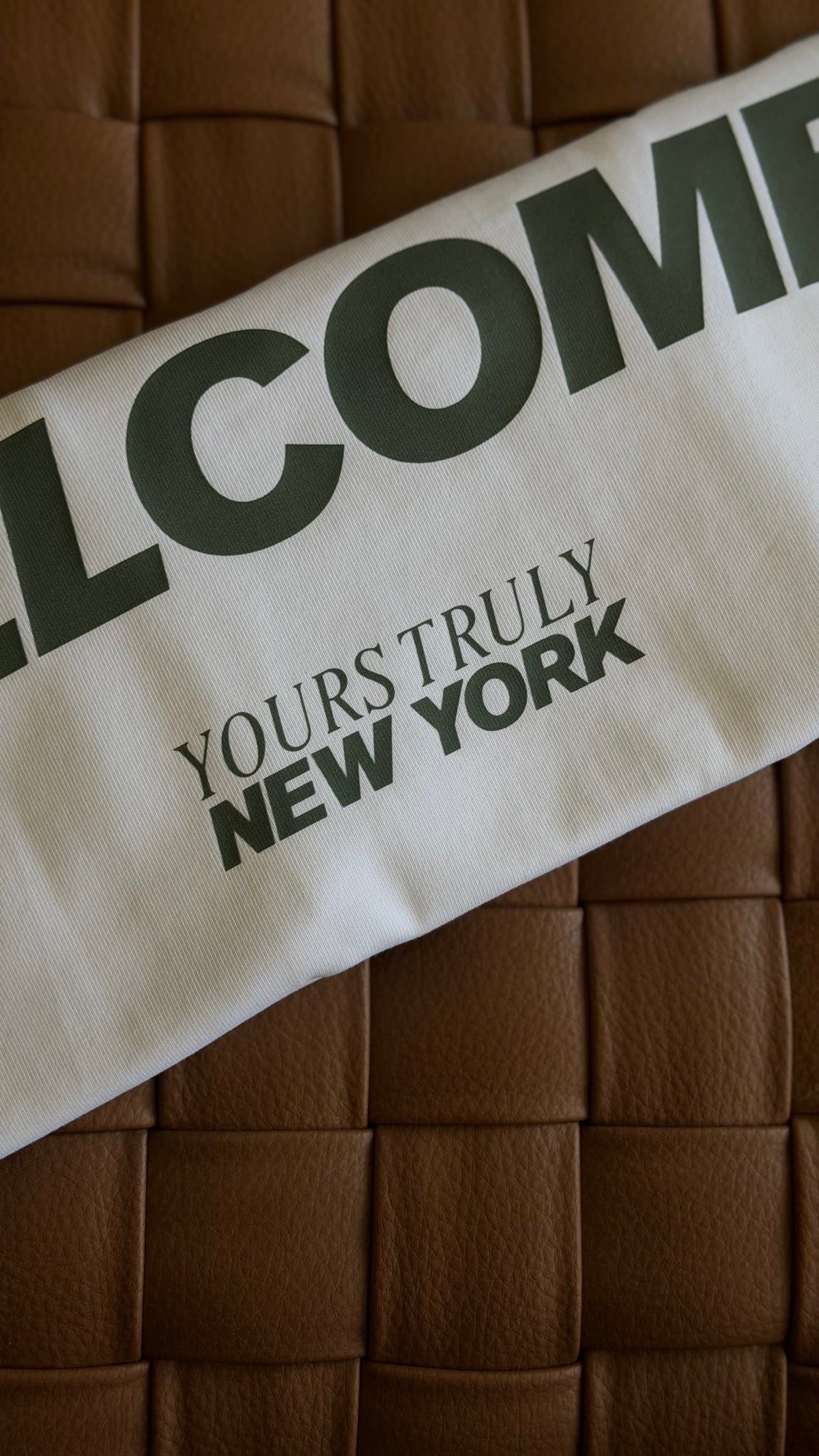Back print detail of the white All Races Welcome oversized tee in dark green